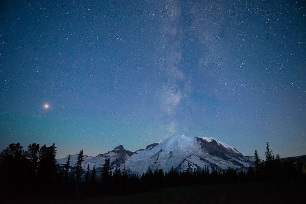 The lights of climbers can be seen on the mountain as the Milky Way rises behind Mt Rainier